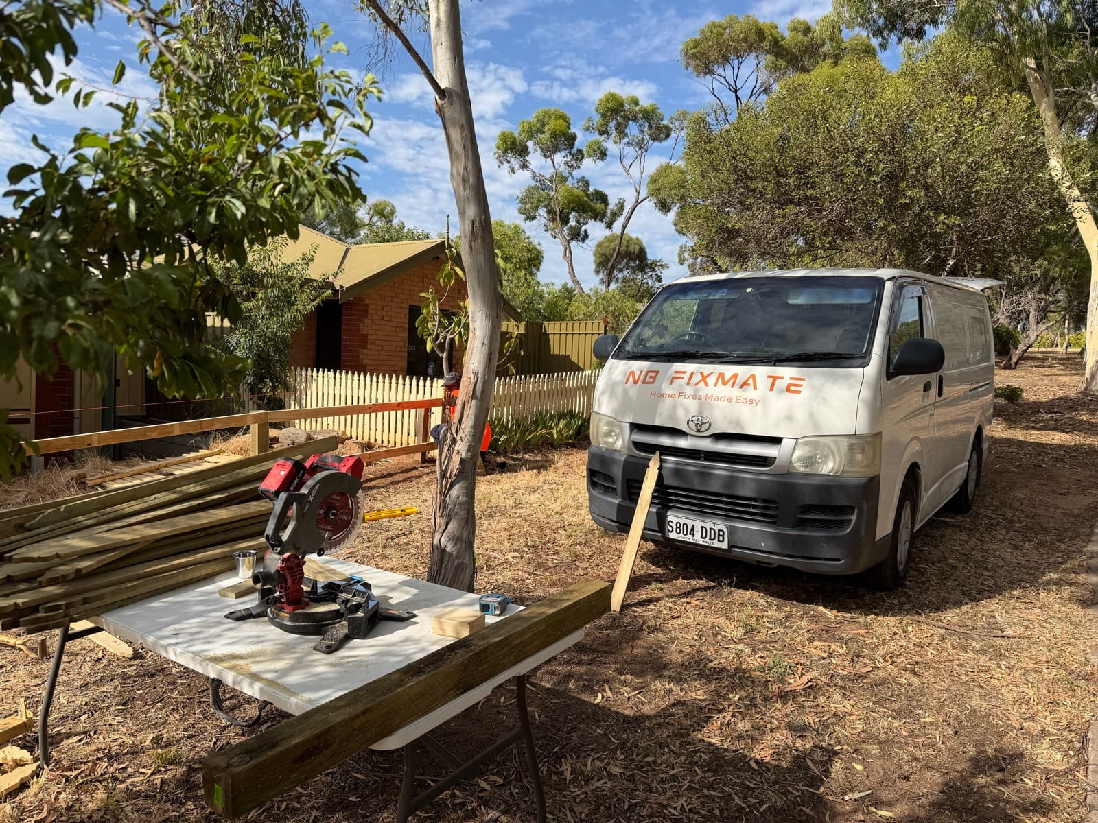 NB Fixmate branded van and miter saw set up during timber picket fence installation in Adelaide