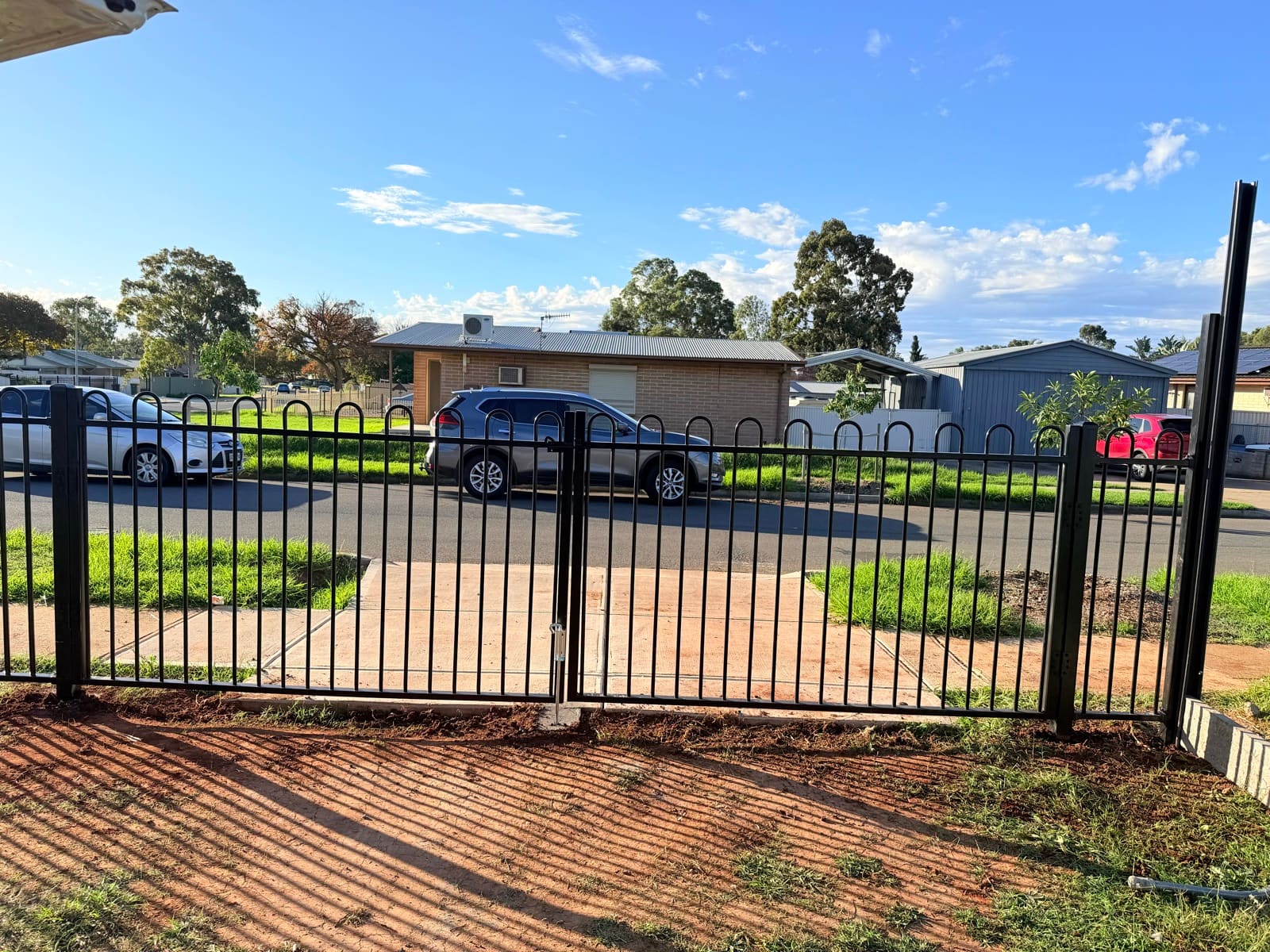 Black tubular hoop-top metal fence with a double gate installed along a residential Adelaide front yard