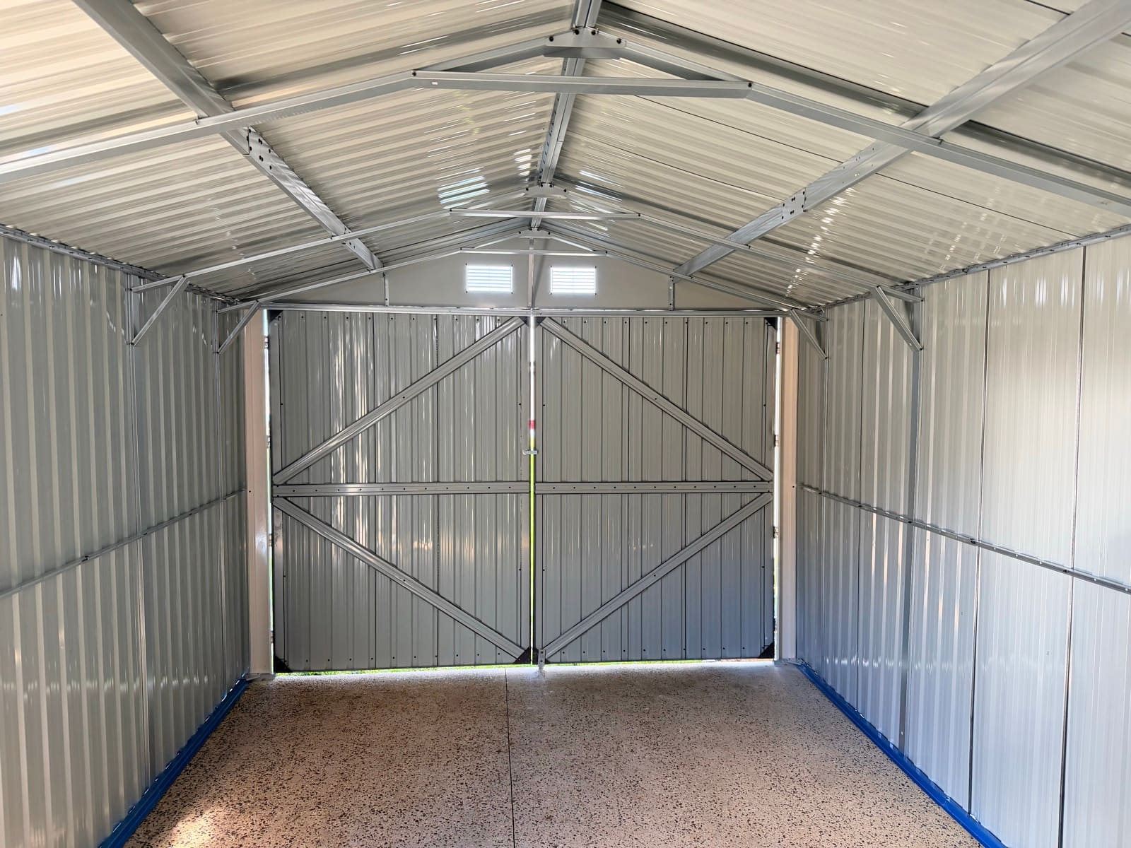 Interior of a newly installed metal garden shed on a concrete slab