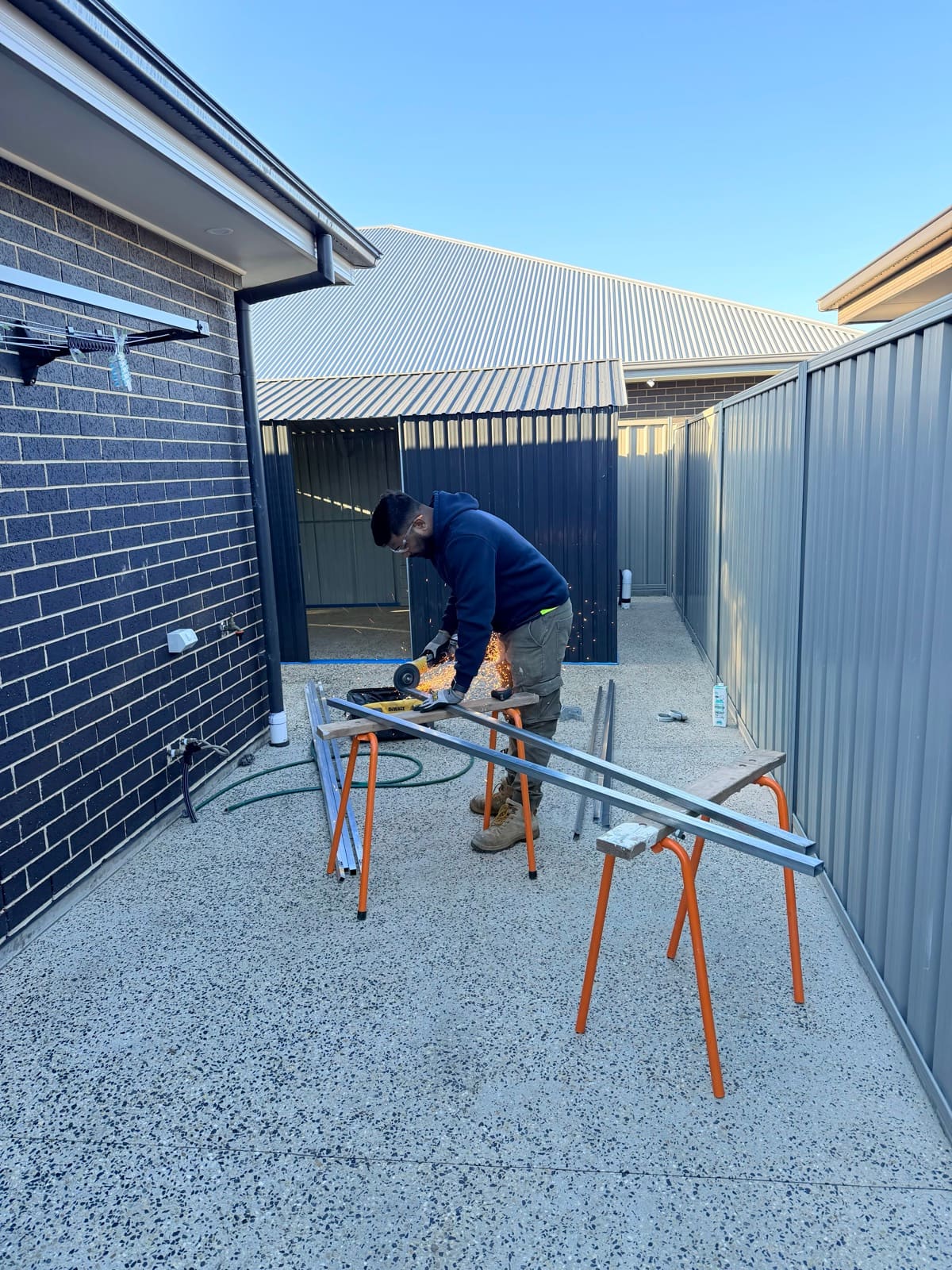 Handyman cutting metal framing for garden shed installation